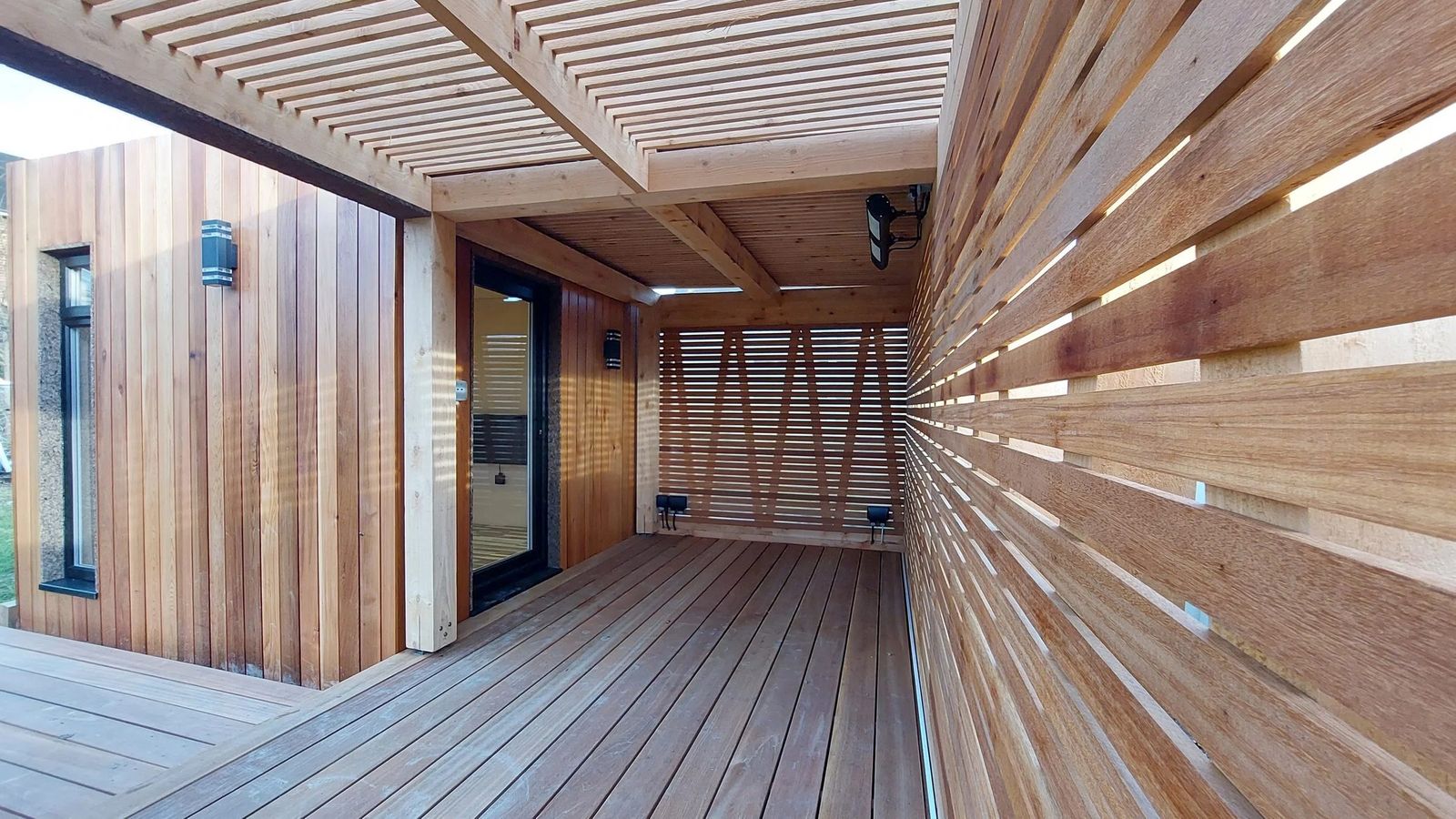 Covered deck walkway along a cedar-clad garden room